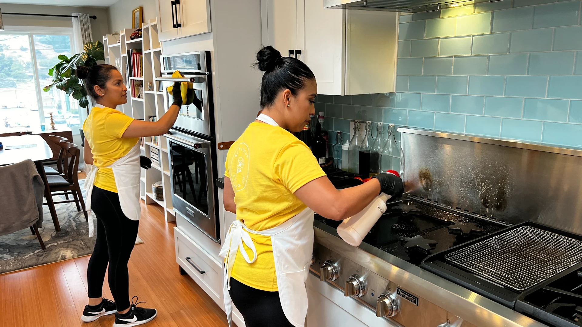 Buttercup team cleaning a stovetop and oven surfaces