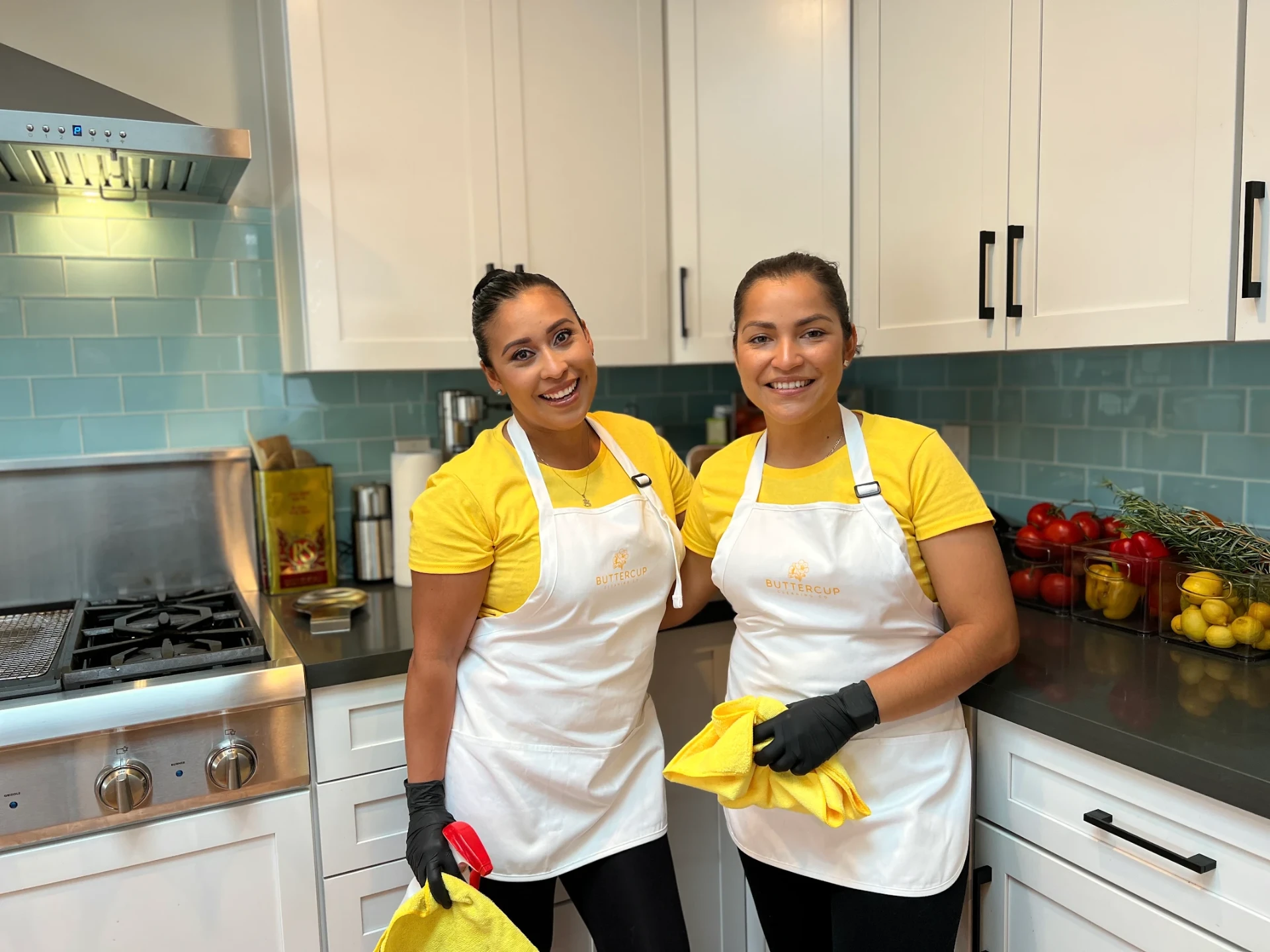 Two Buttercup team members smiling in their yellow uniforms and white aprons